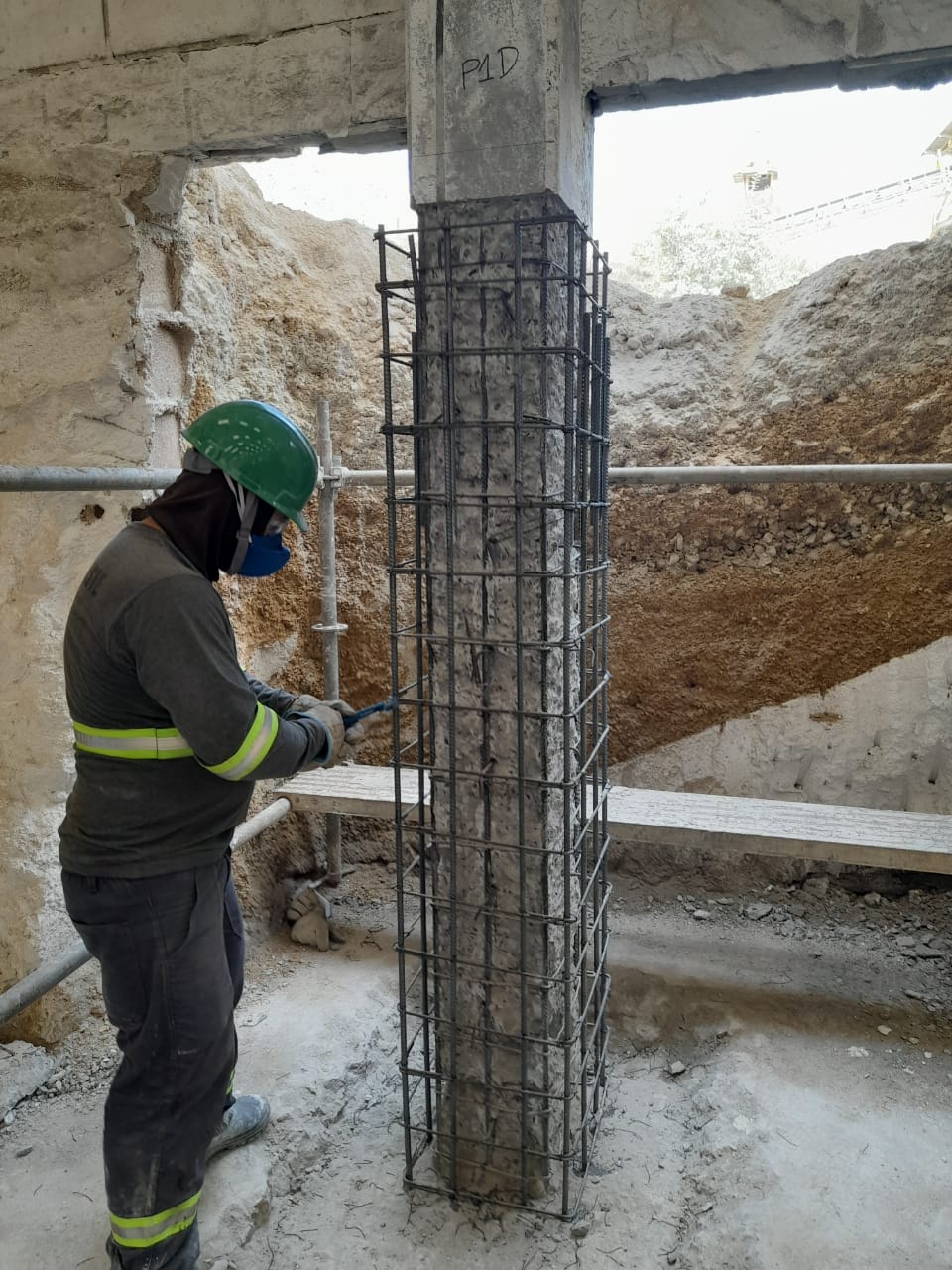 Profissional trabalhando junto à armadura do pilar