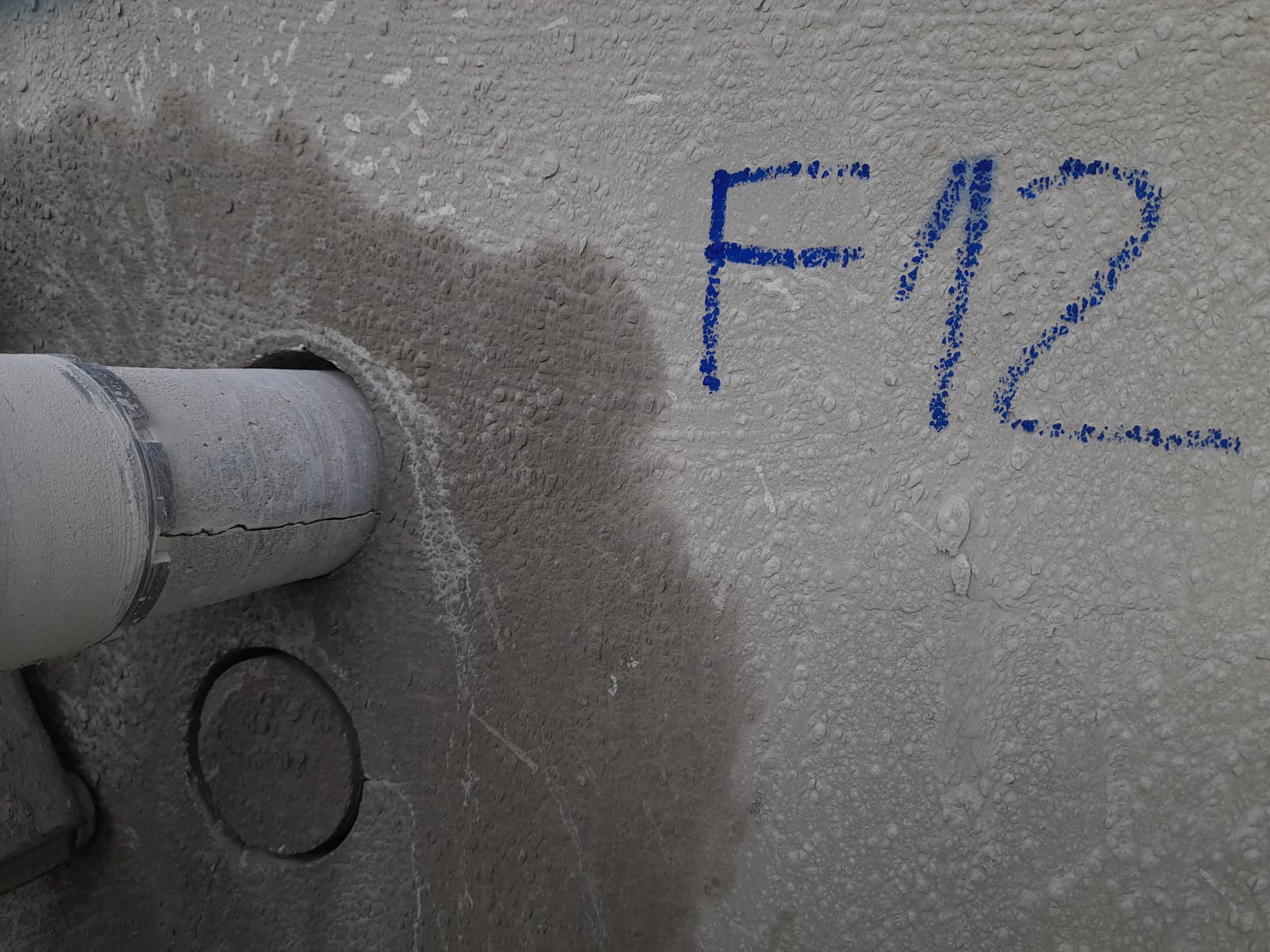 Ponto de extração identificado como F12 na parede de concreto