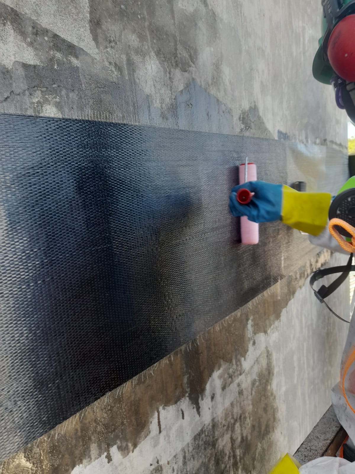 Detalhe do trabalho com rolo sobre a manta de fibra de carbono