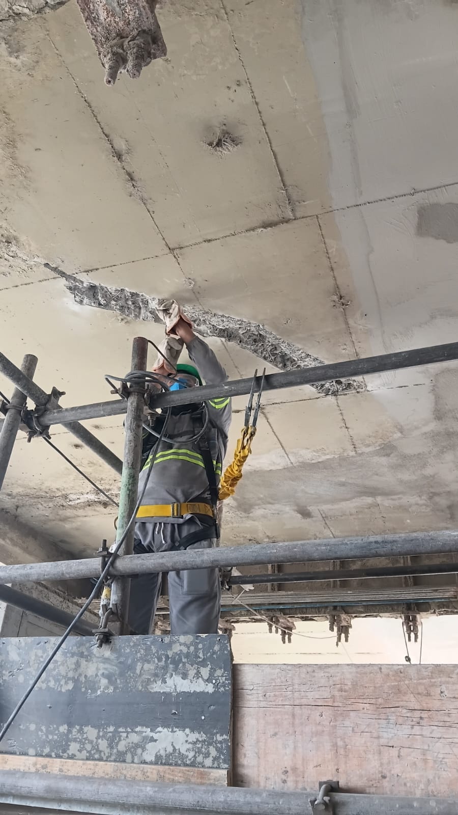 Profissional trabalhando sob uma laje de concreto